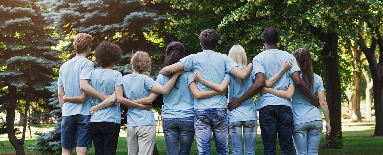 Photo of group with arms around each other.